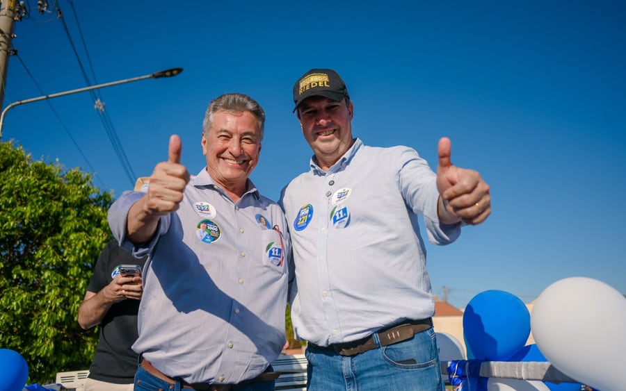 Roberto Hashioka e o governador Eduardo Riedel fazem sinal de positivo lado a lado, sob céu azul, durante agenda em Nova Andradina.