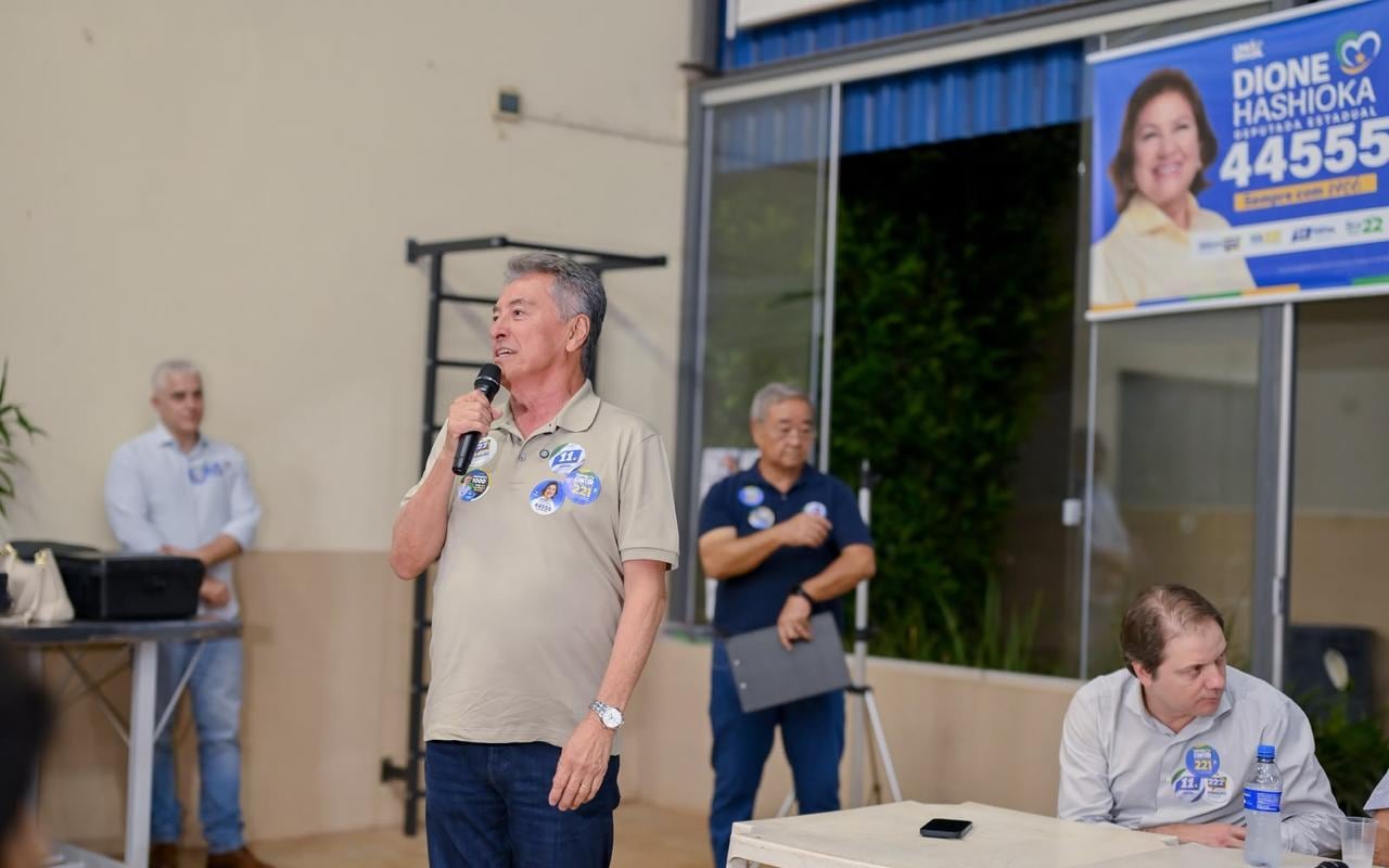 Roberto Hashioka fala ao microfone, em pé, durante encontro com apoiadores e membros da colônia japonesa em Campo Grande.